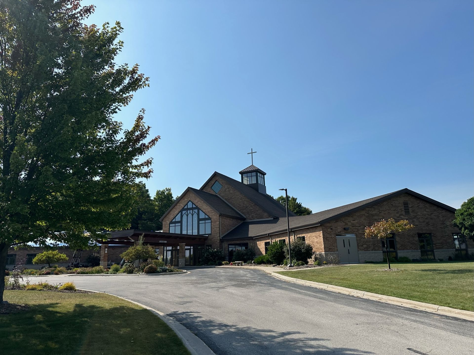 A large brick church with a cross on top of it