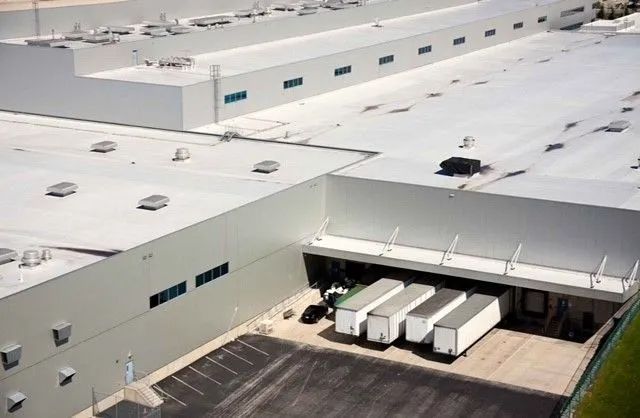 An aerial view of a large white building with a white roof.