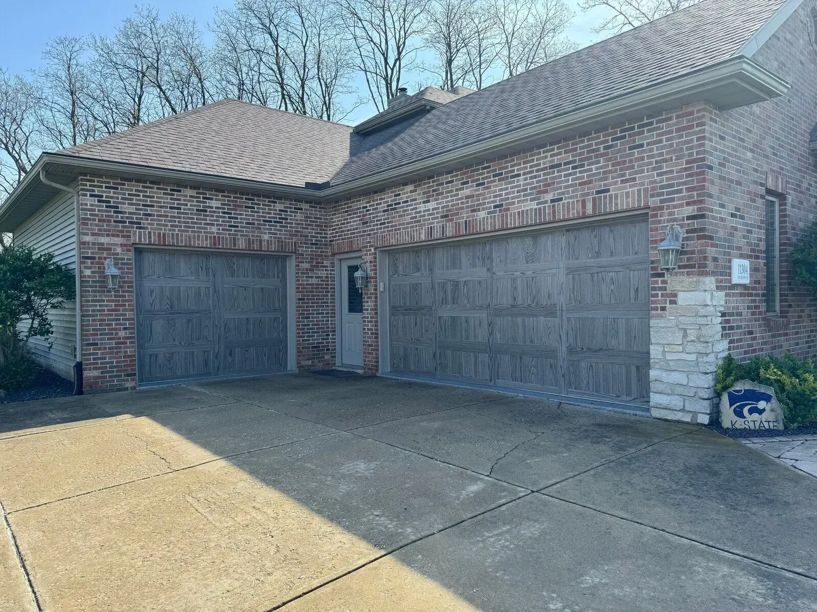 Brick house with two garage doors and a concrete driveway.