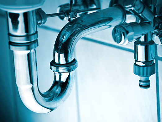 Shiny chrome plumbing pipes under a sink.