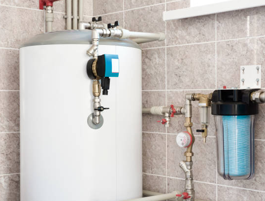 Water heater and filter in a tiled room; white tank with plumbing, a filter, and control box.