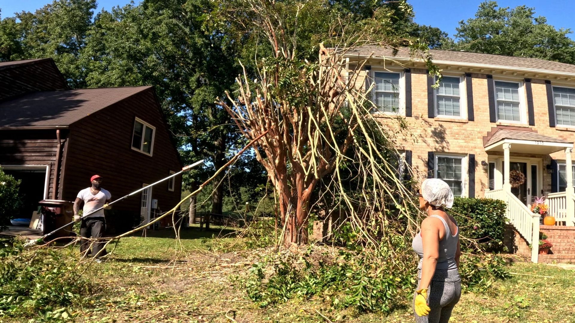 a man and a woman are standing in front of a house