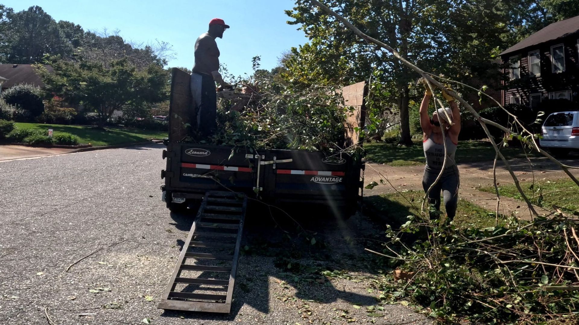 a man is standing next to a trailer with a ramp attached to it
