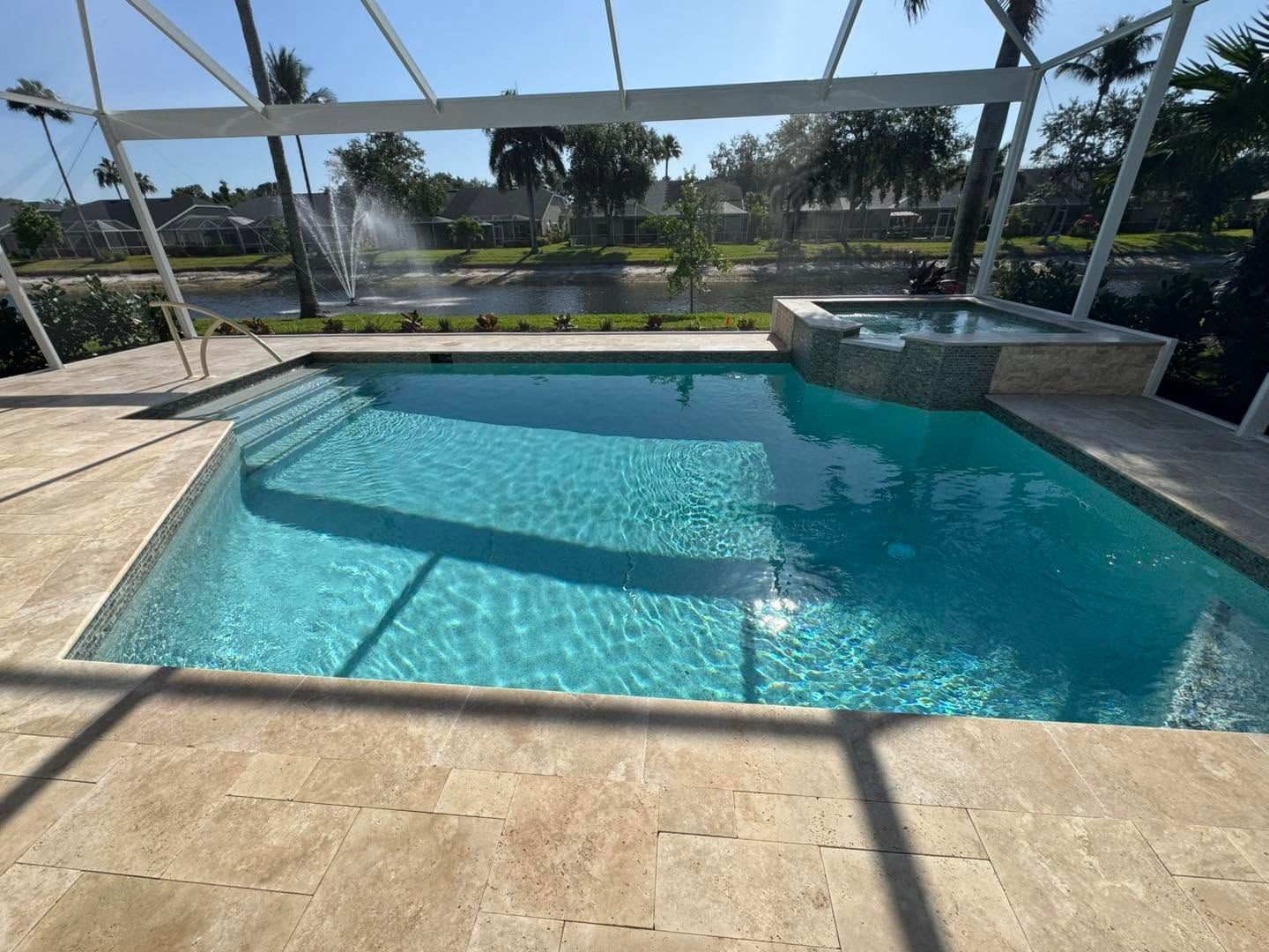 Backyard pool with turquoise water, screened enclosure, and stone patio in bright sunlight