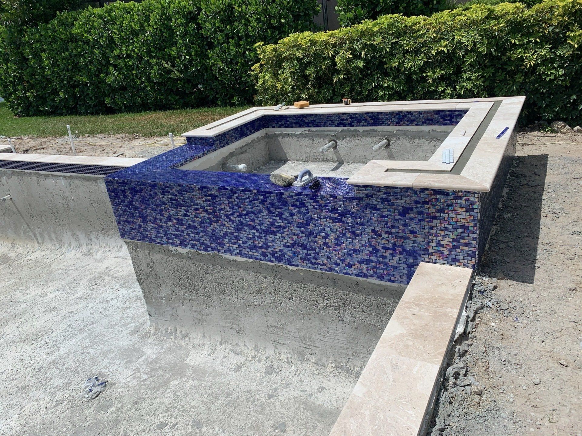 Concrete fountain basin with blue-tiled rim and still water in an outdoor courtyard