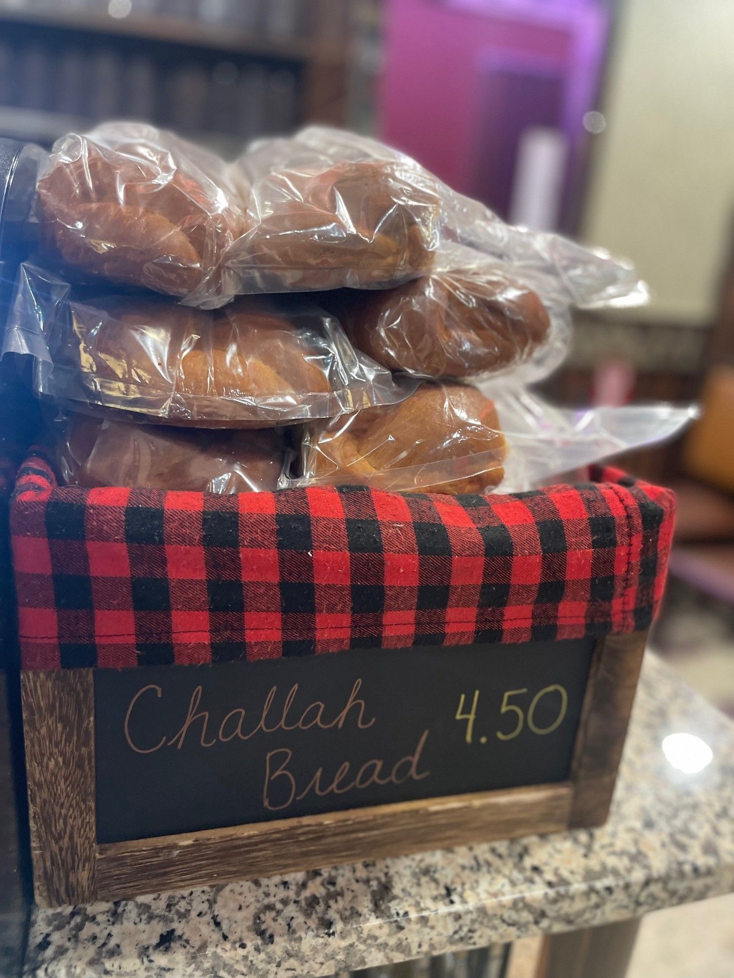 A basket of challah bread is sitting on a counter.
