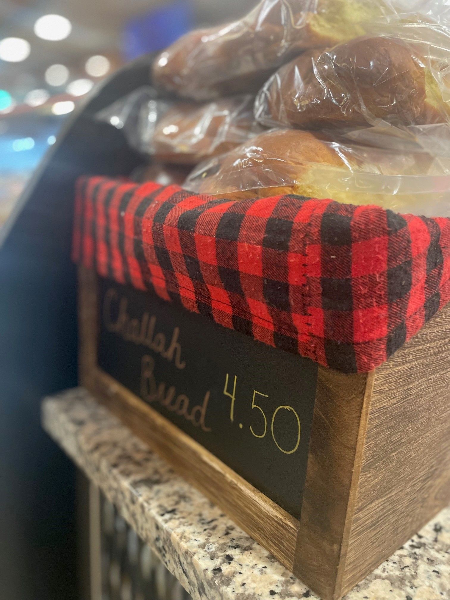 A basket of challah bread is sitting on a counter.