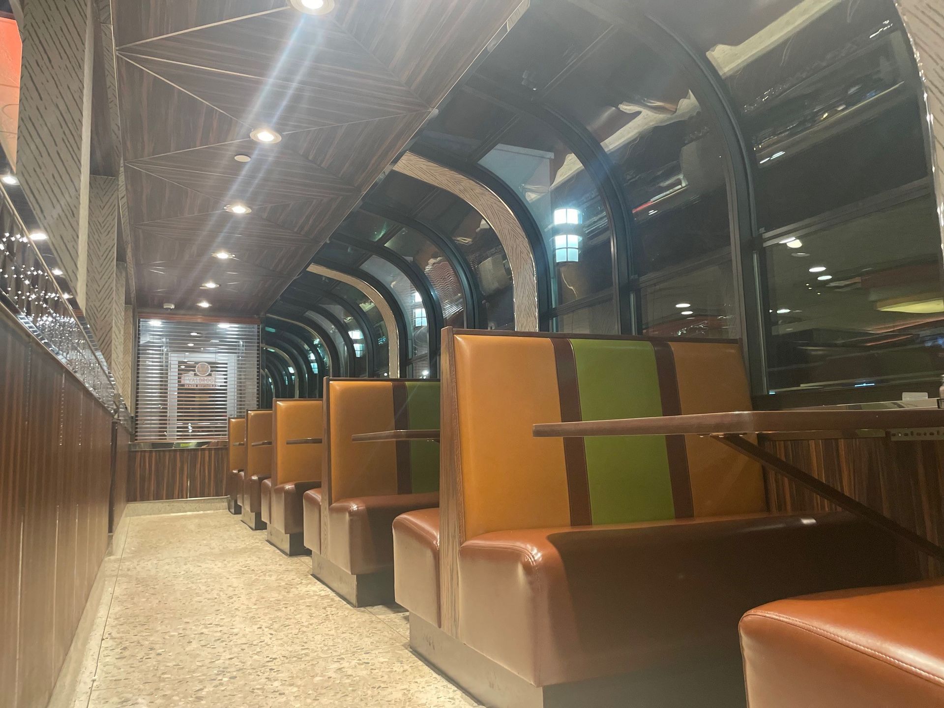 A row of booths in a restaurant with tables and chairs