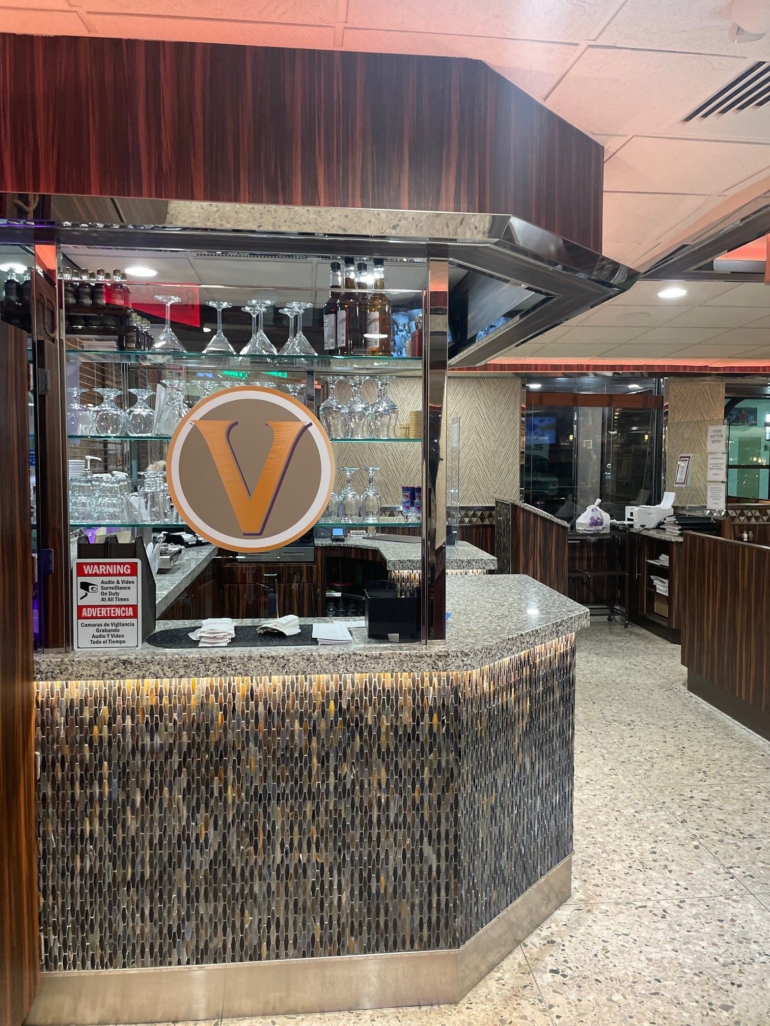 A restaurant with a bar and a sign that says v on it.