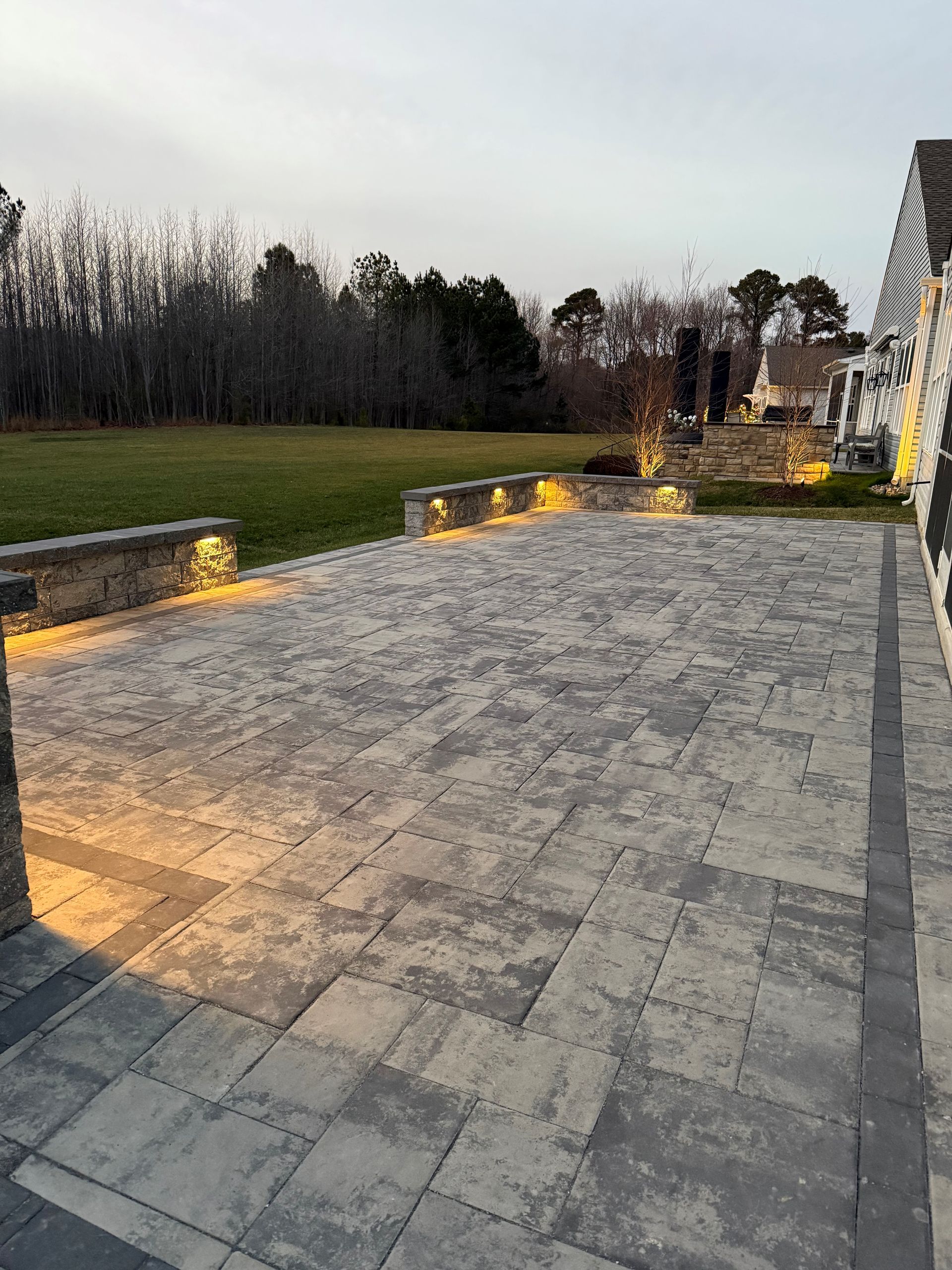 A patio with lights on it and a field in the background.