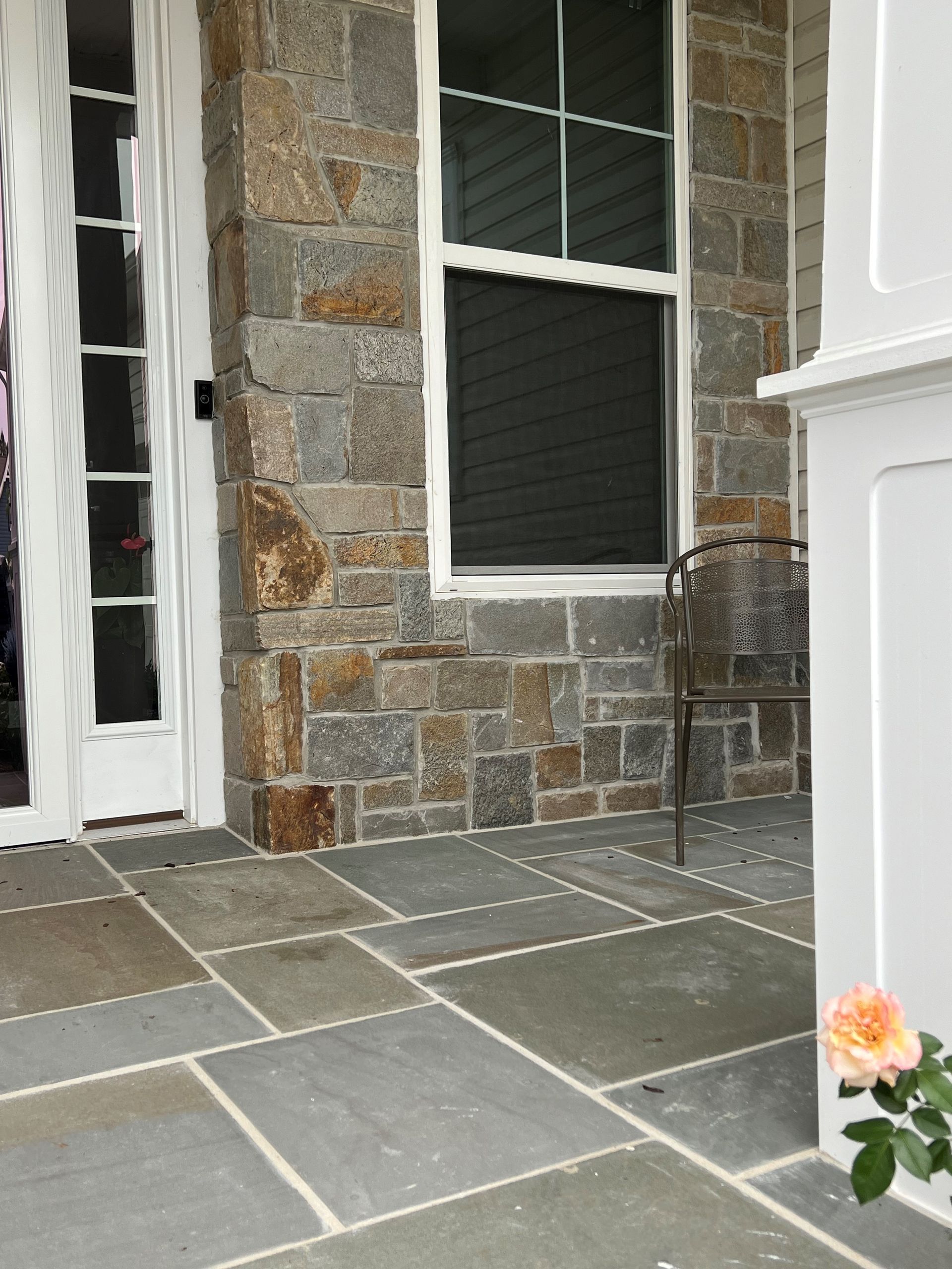 A brick driveway leading to a house with a sunset in the background.