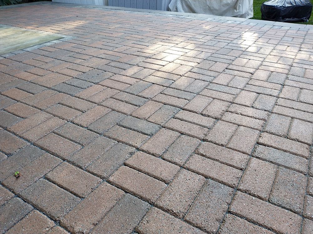 A close up of a brick driveway with a brick pattern.