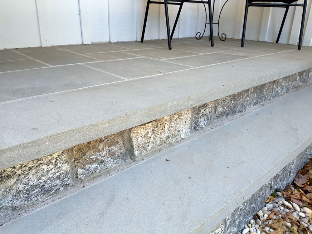 A porch with a table and chairs on it
