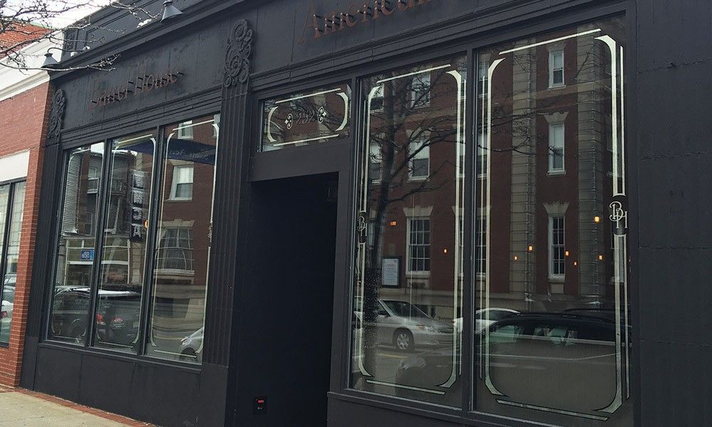 A black building with a lot of windows and a brick building in the background.