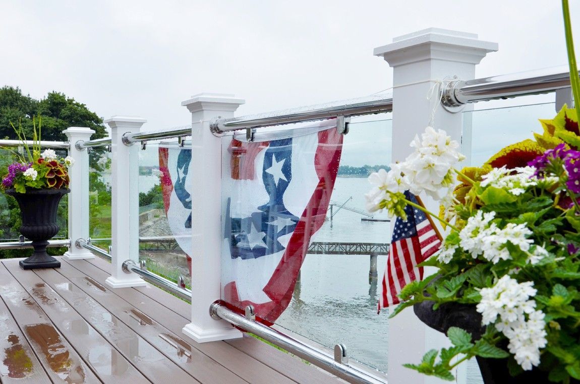 A wooden deck with a railing and flowers on it.