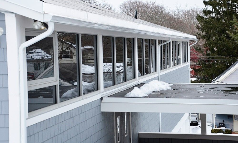 A house with a lot of windows and snow on the roof
