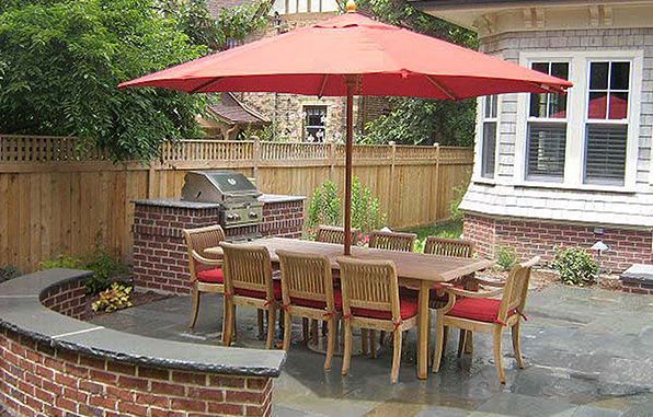 A patio with a table and chairs under an umbrella.