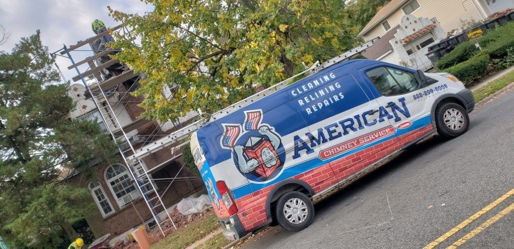 American chimney services van is parked on the side of the road in front of a house.