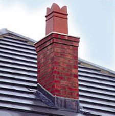 A red brick chimney is on the roof of a house.