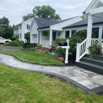 There is a walkway leading to the front of the house.