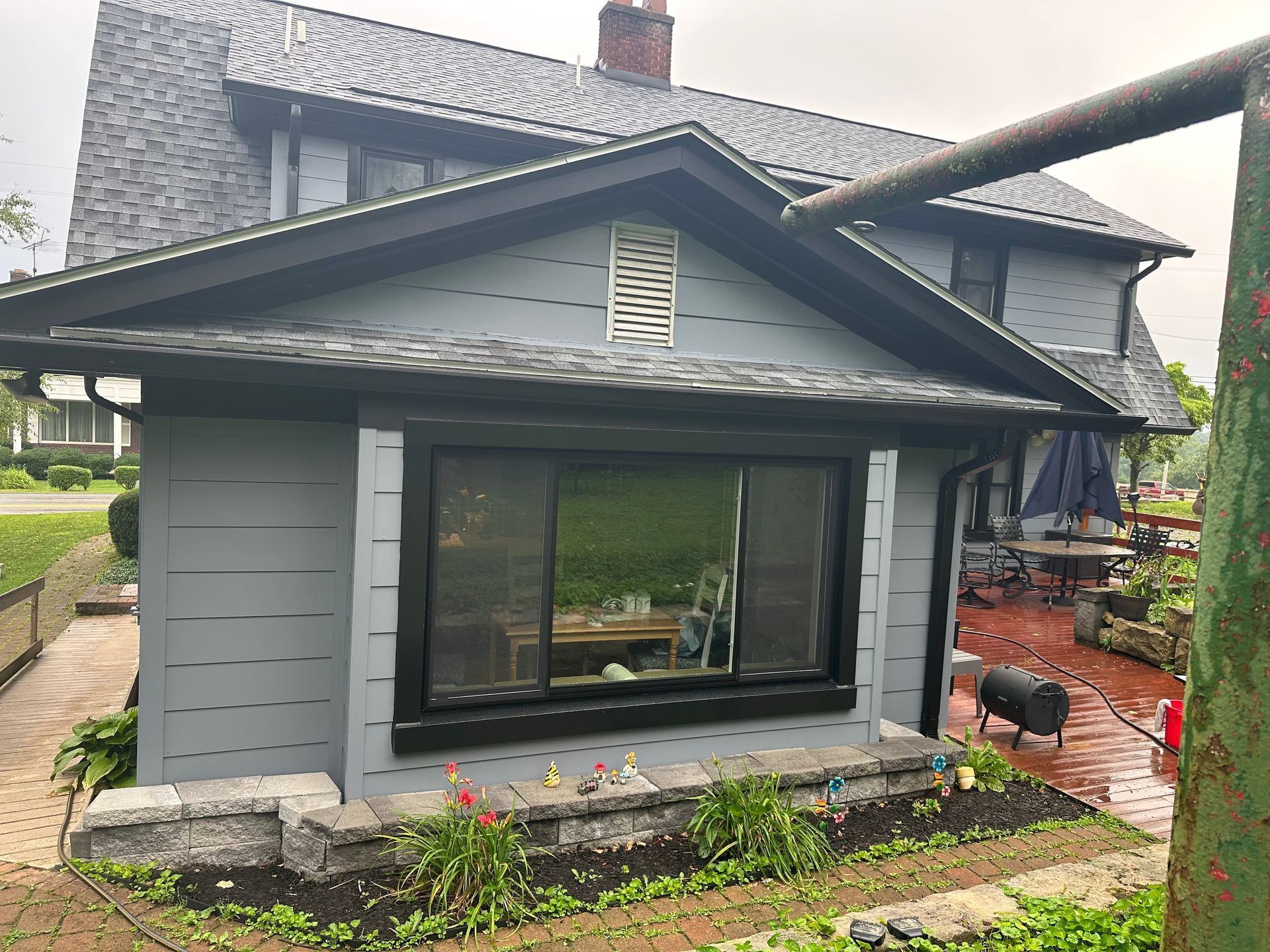 A house with a black roof and a large window