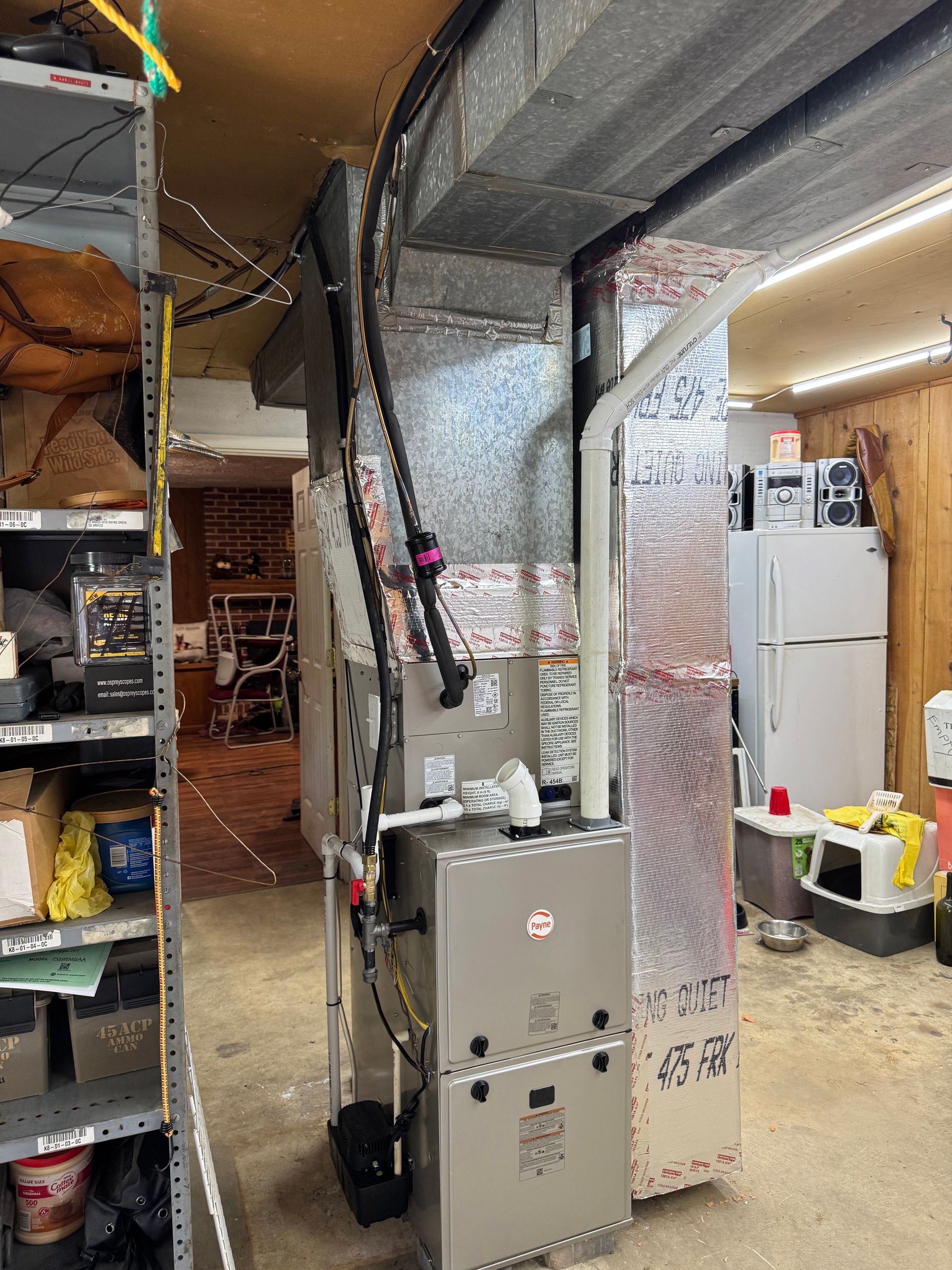 Utility room with HVAC equipment, metal ducts, shelves, and a white water heater.