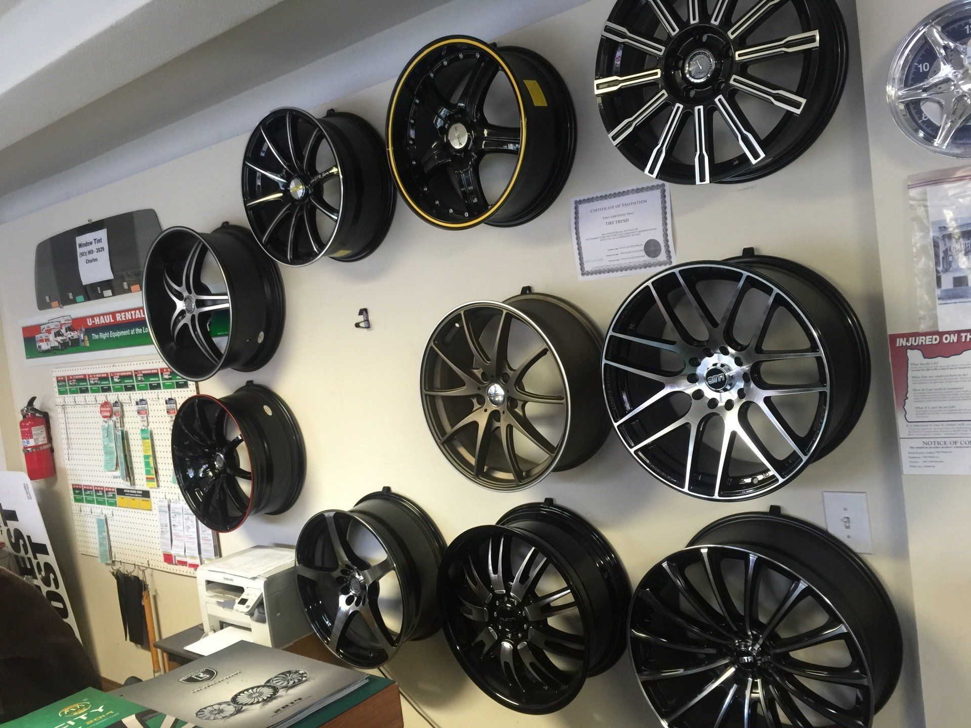 A bunch of wheels are hanging on a wall in a store