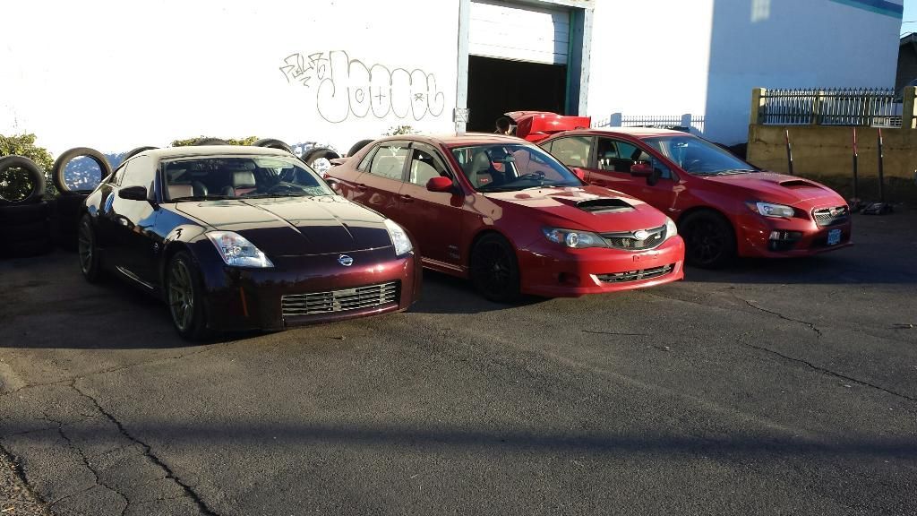 Three cars are parked in front of a building with graffiti on it