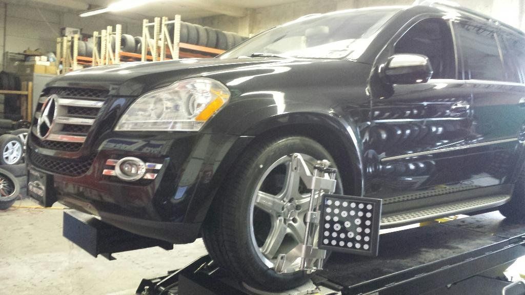 A black suv is sitting on a lift in a garage.