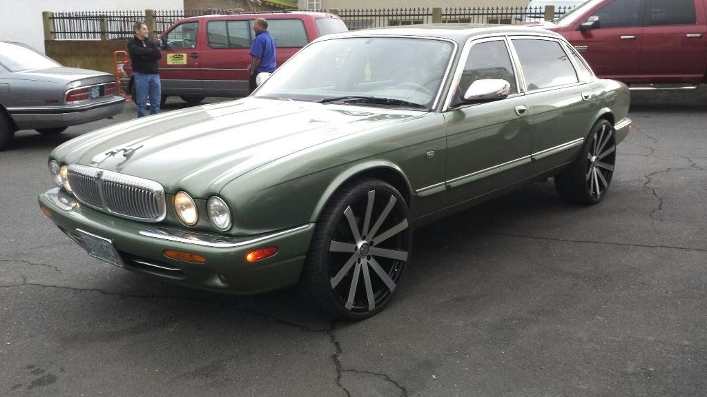 A green jaguar is parked in a parking lot