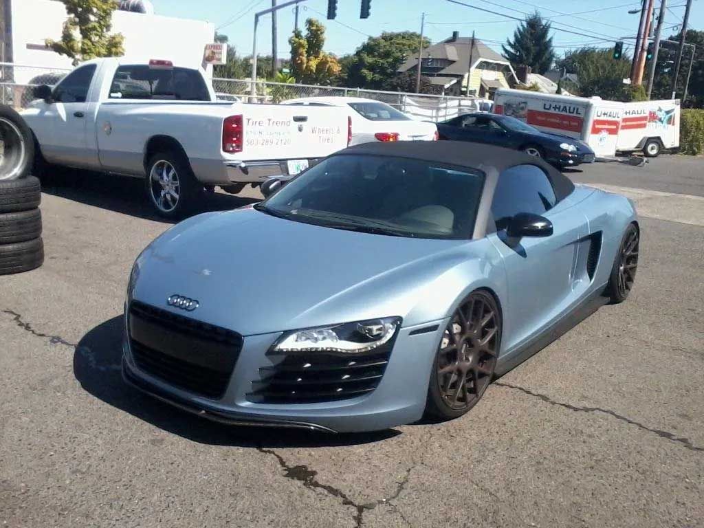 A silver sports car is parked in a parking lot