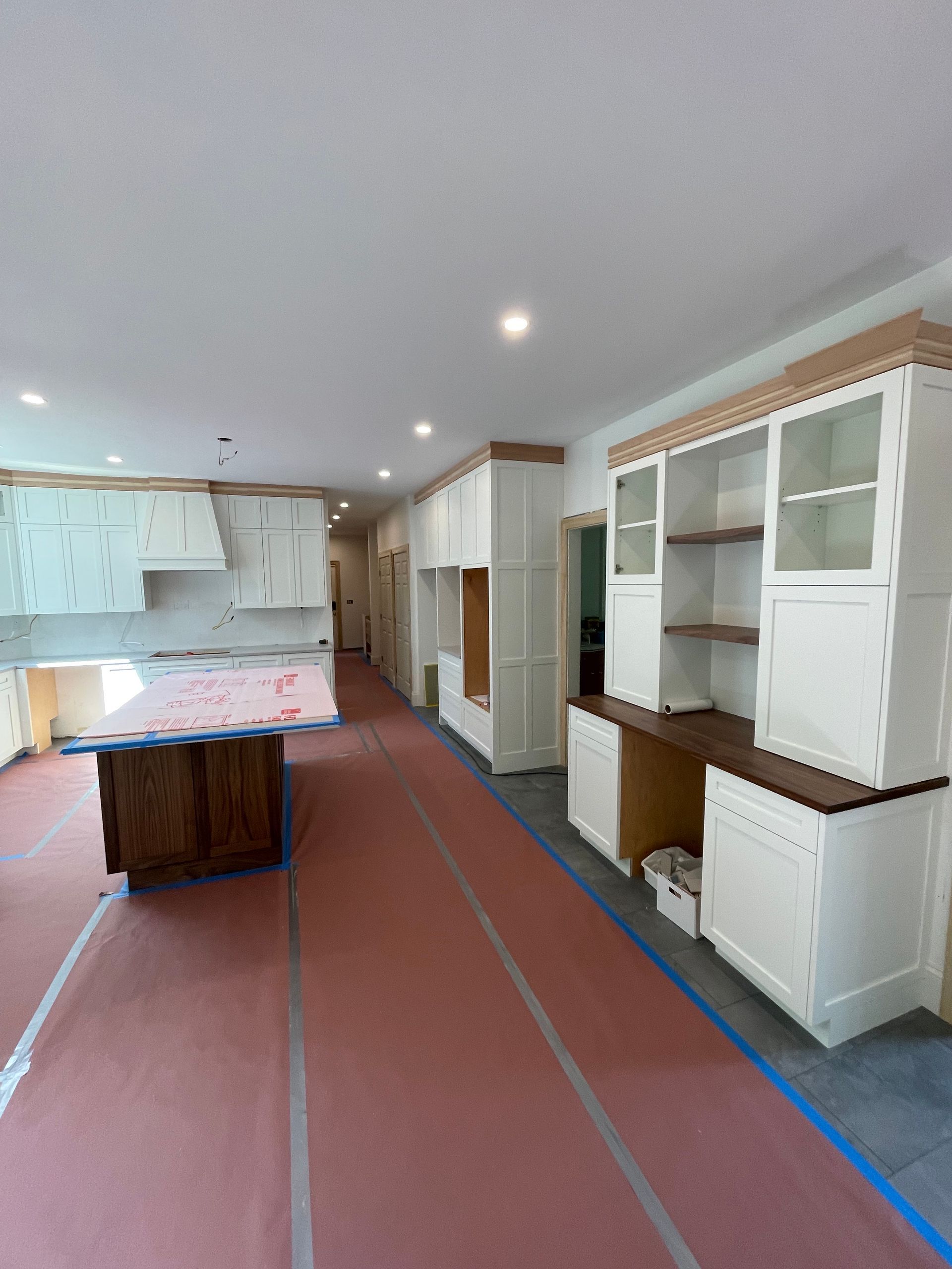 A kitchen with white cabinets and wooden counter tops is being remodeled.