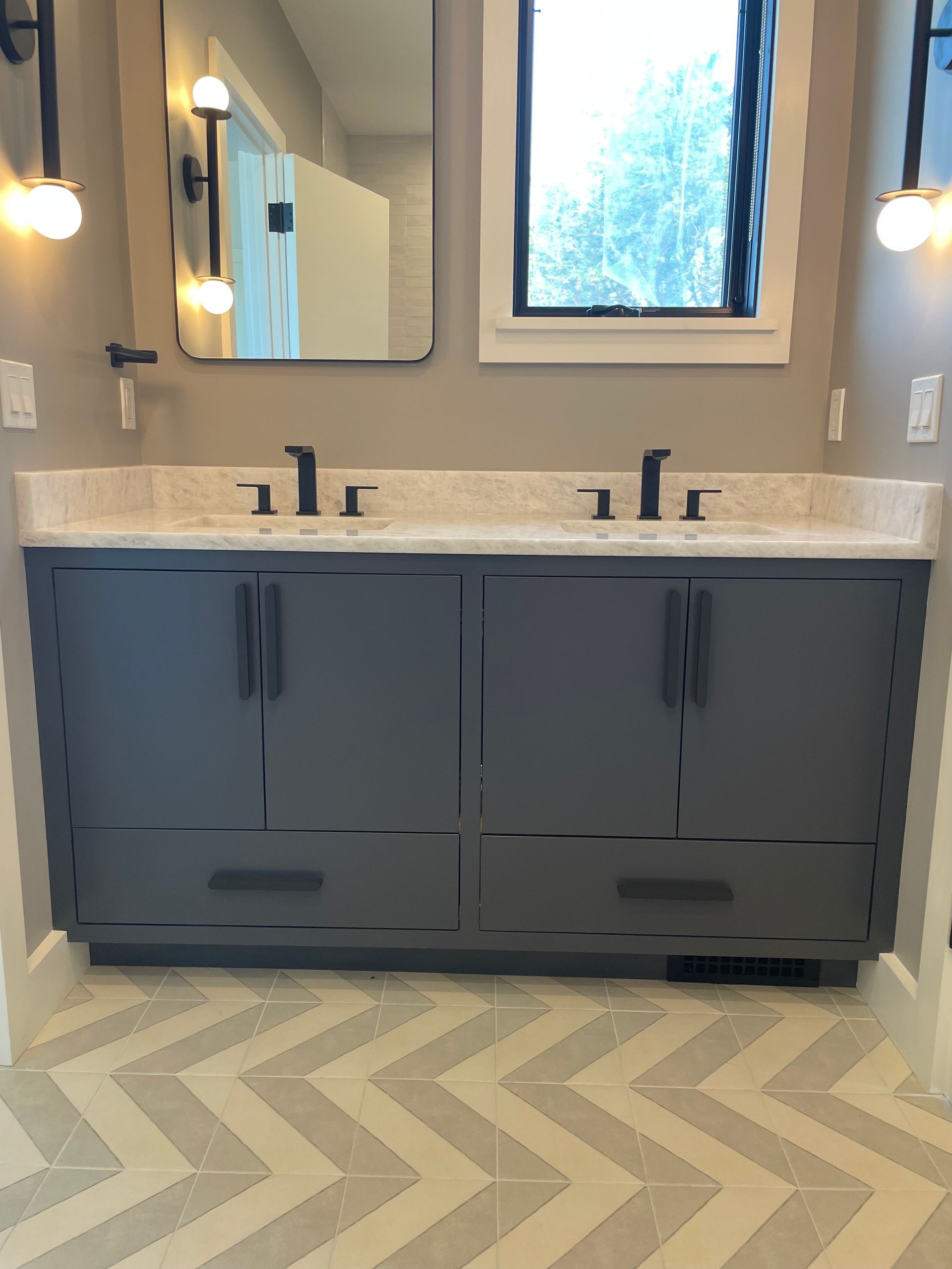 A bathroom with two sinks and a mirror.