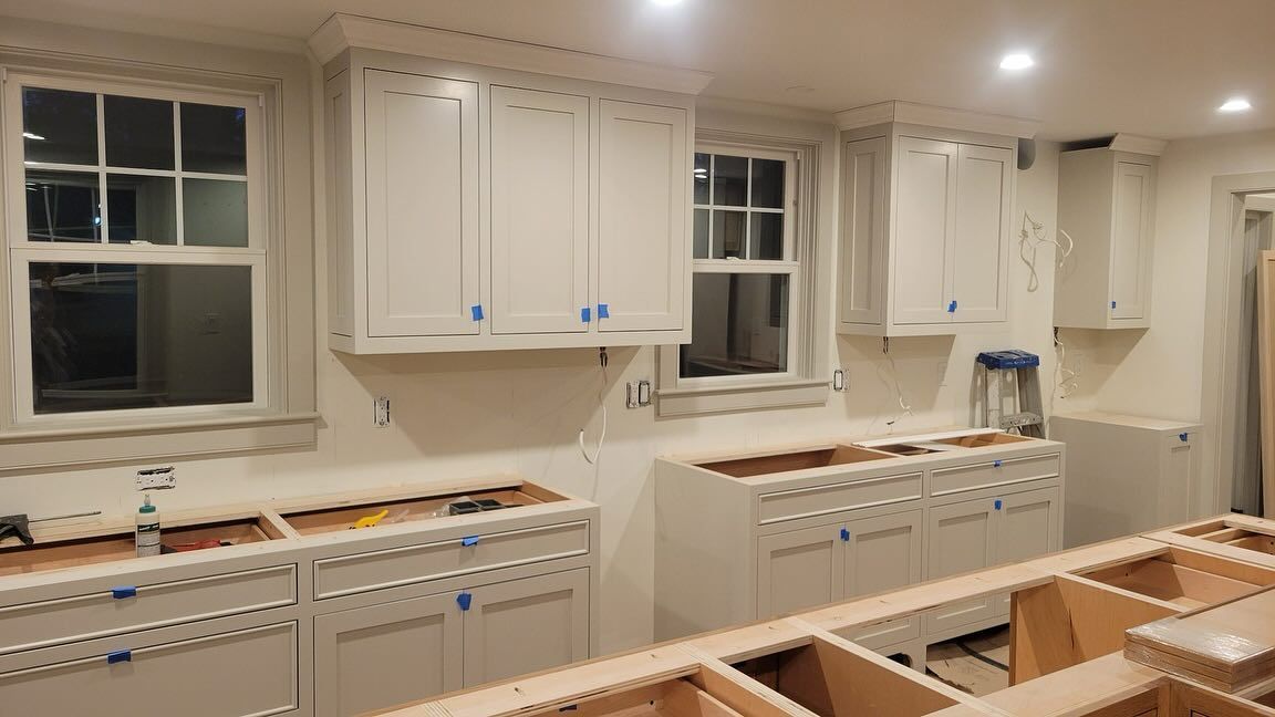 A kitchen is being remodeled with white cabinets and counter tops.