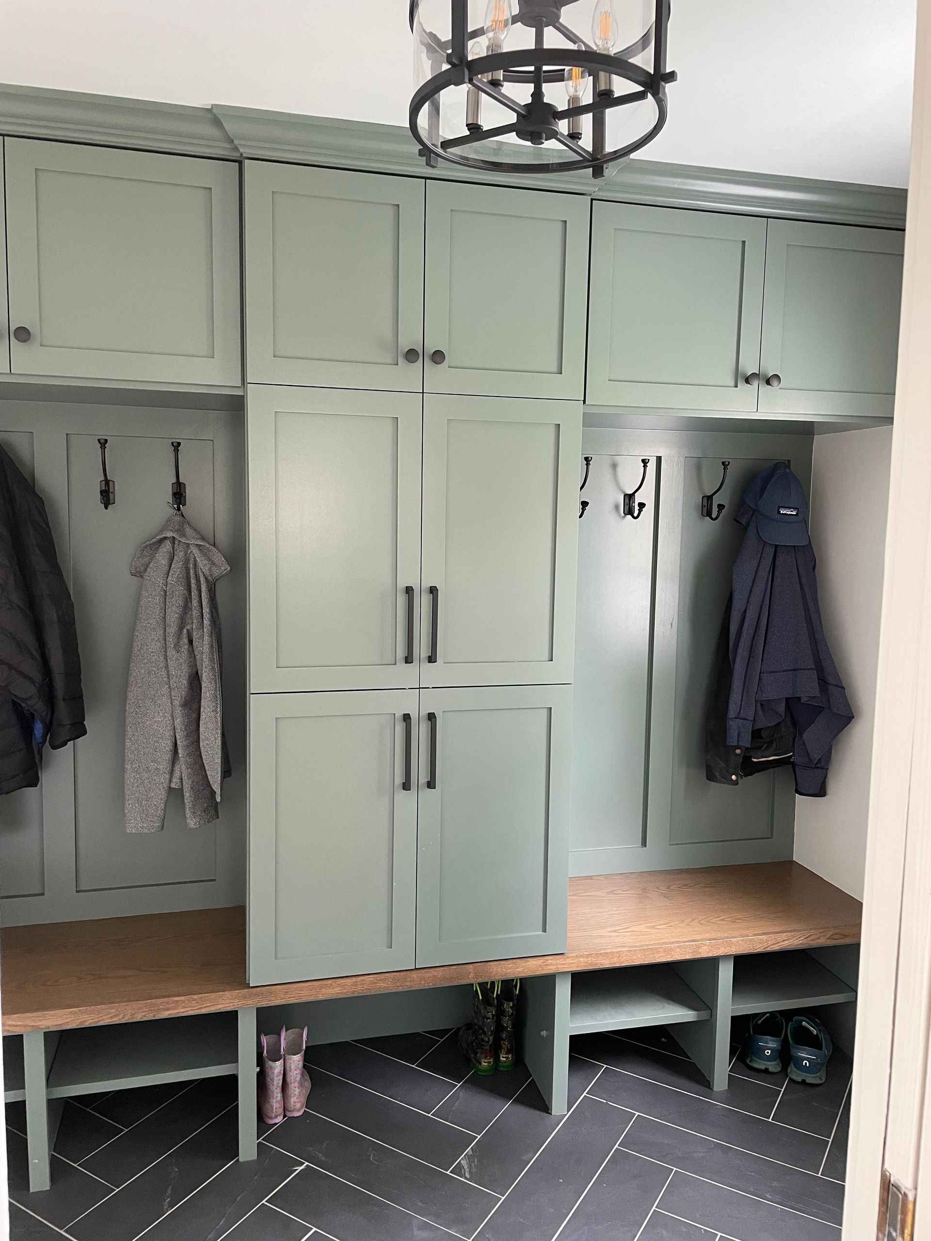 A mud room with lots of cabinets and a bench.