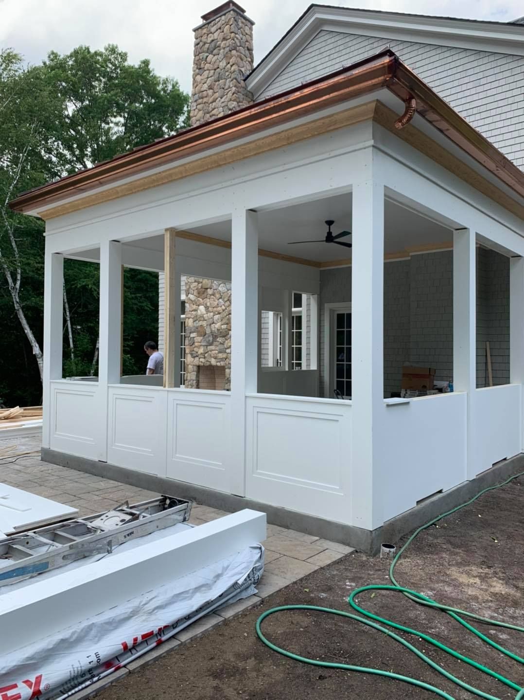 A white house with a copper roof is being built.