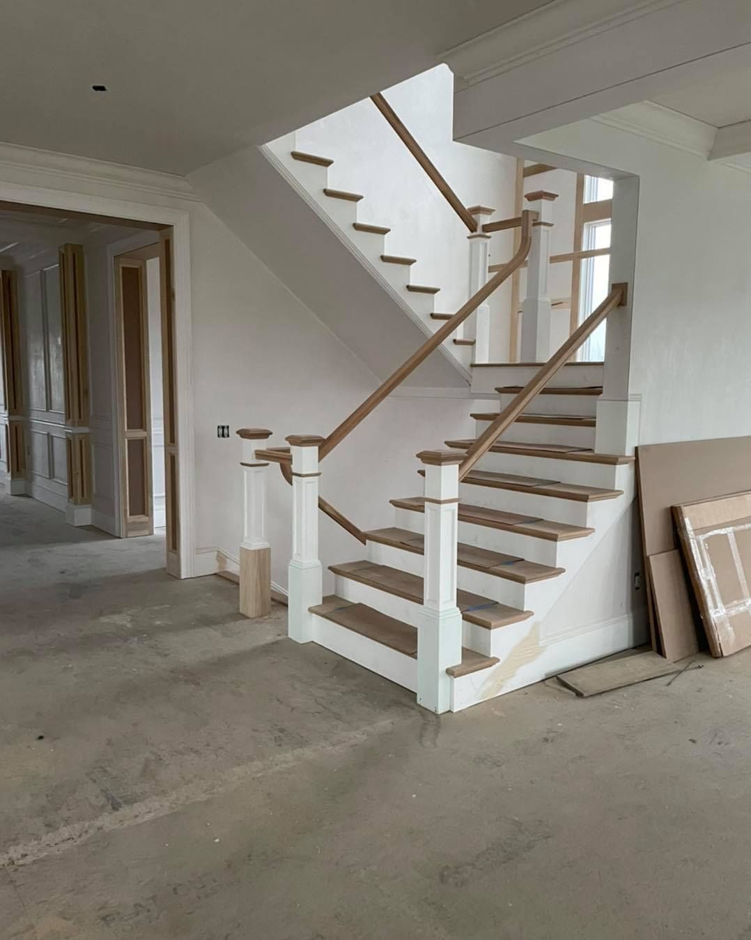 An empty room with a staircase and a wooden railing.