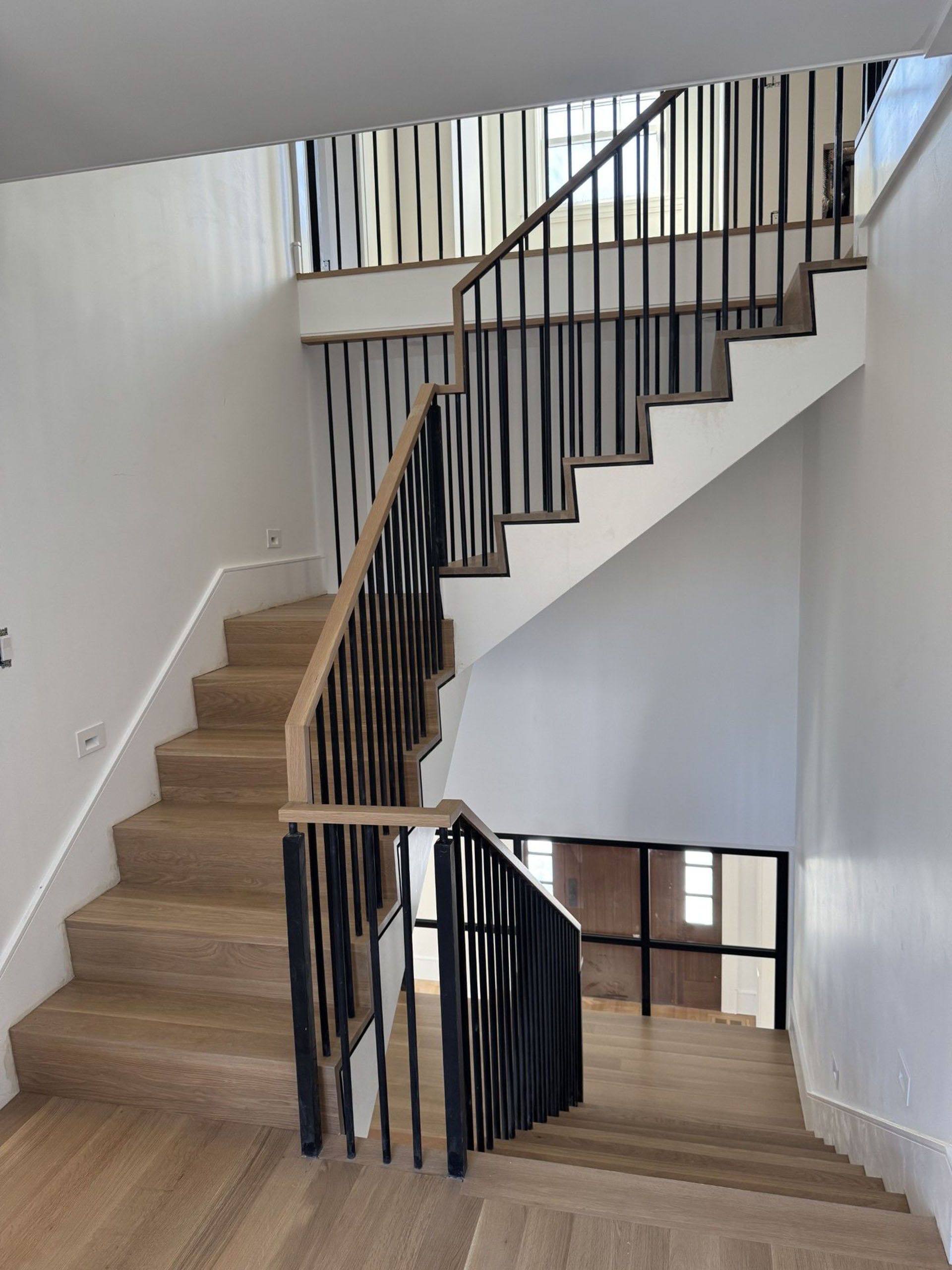 A staircase with wooden steps and a metal railing in a house.