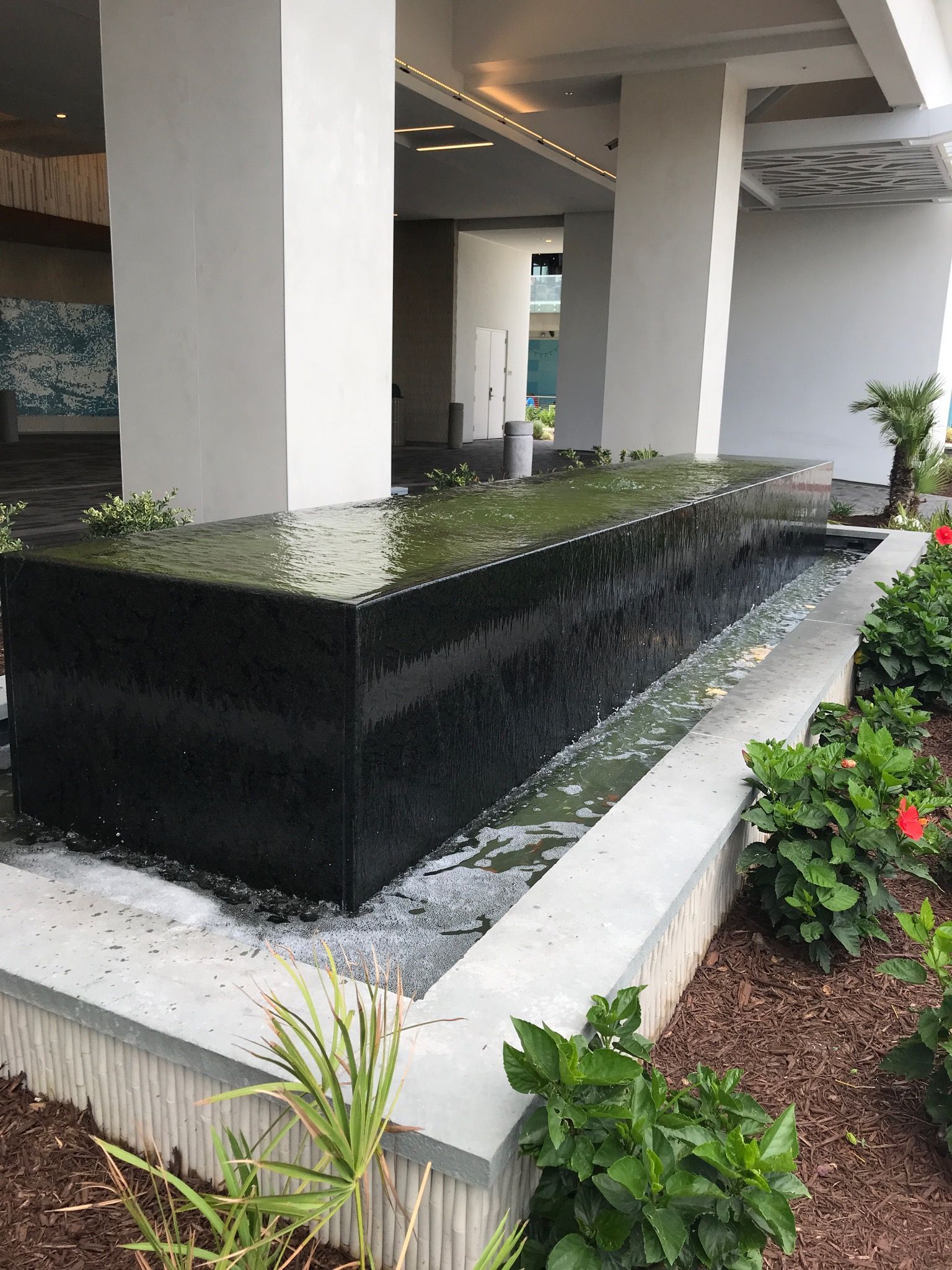 There is a large water fountain in the middle of a garden.