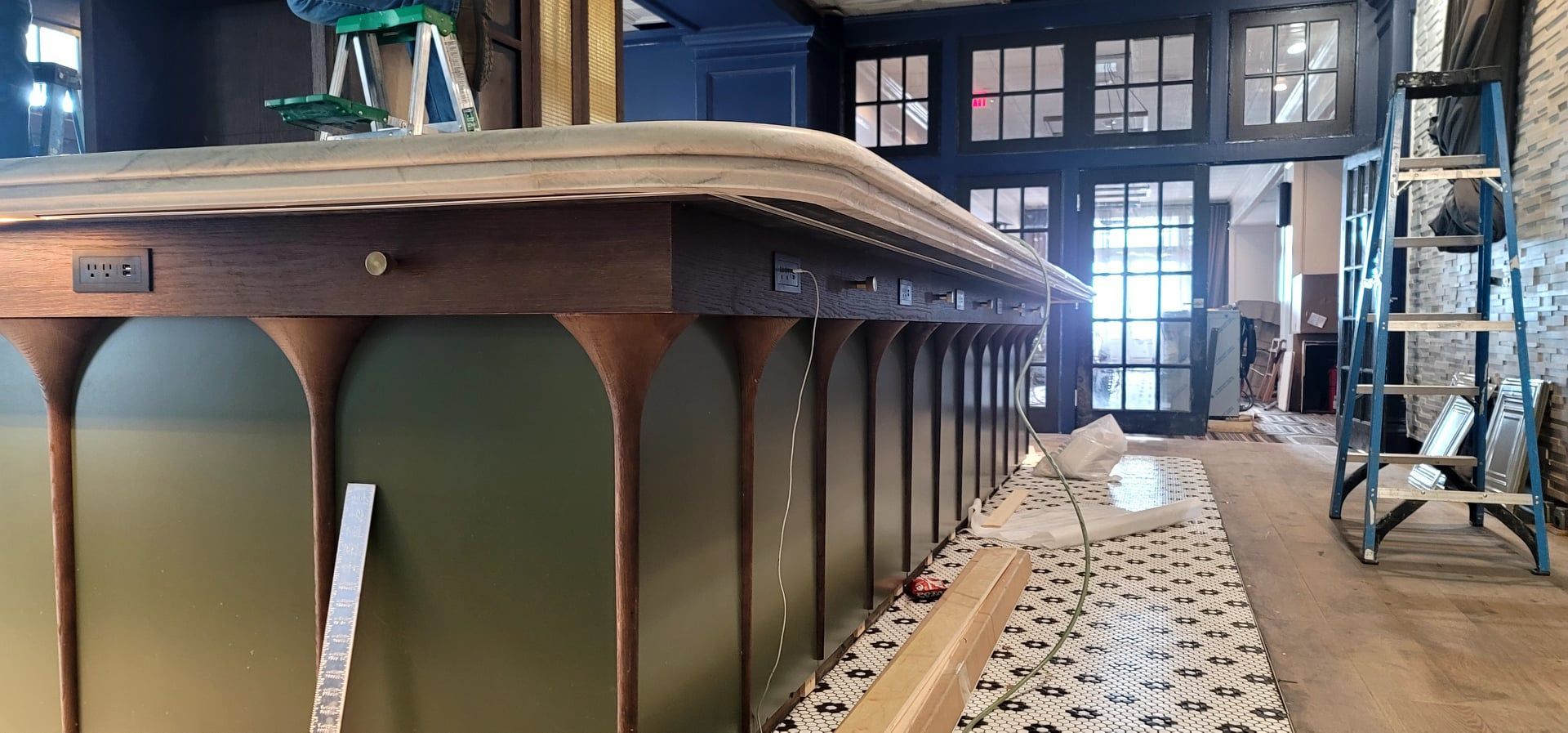 A bar is being built in a restaurant with a ladder in the background.