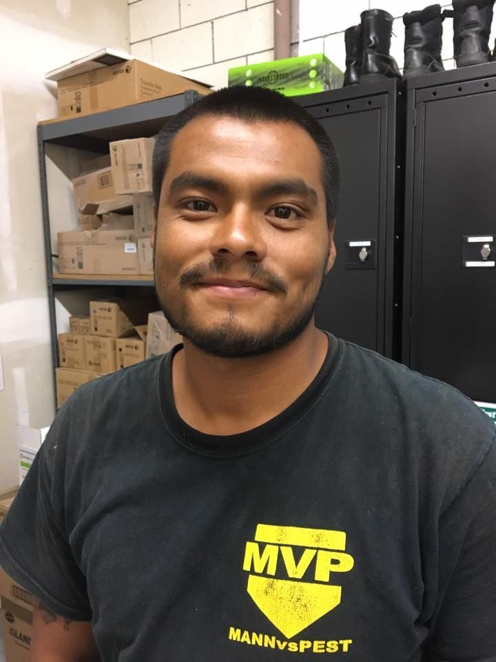 A person smiling, wearing a black t-shirt with a yellow 