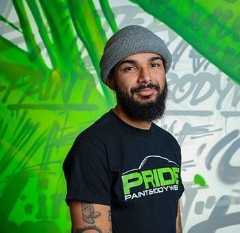 Man in gray beanie and black shirt in front of graffiti.