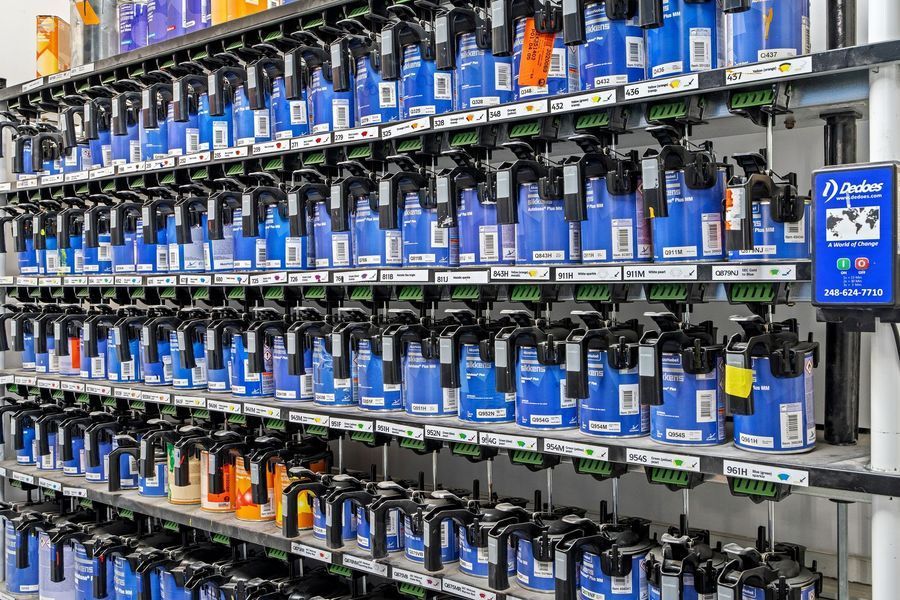 Rows of blue paint bottles on display shelves in a store.