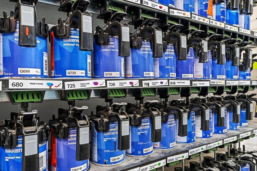 Rows of blue paint cans in a paint store display, organized on shelves with labels.