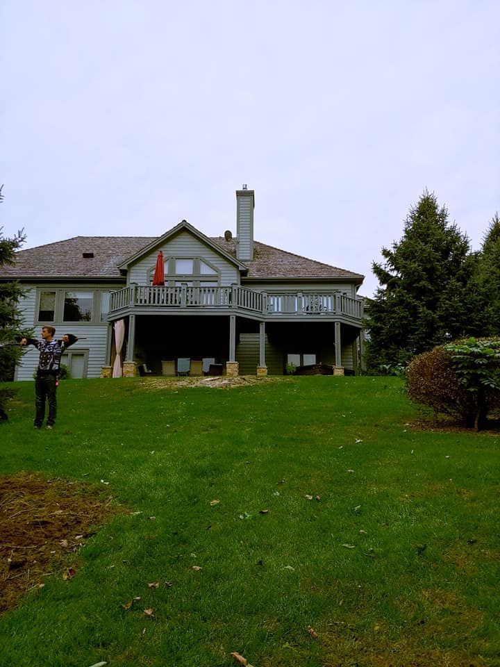 A man is standing in front of a large house