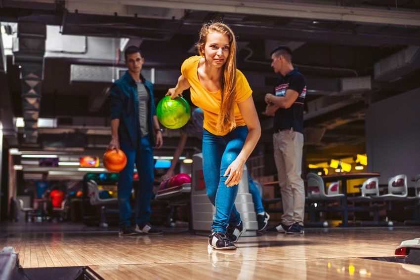 Young woman throwing a bowling ball