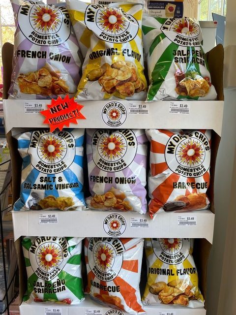Assorted snack chip bags on a store shelf, with French onion, salt and vinegar, and barbecue flavors.