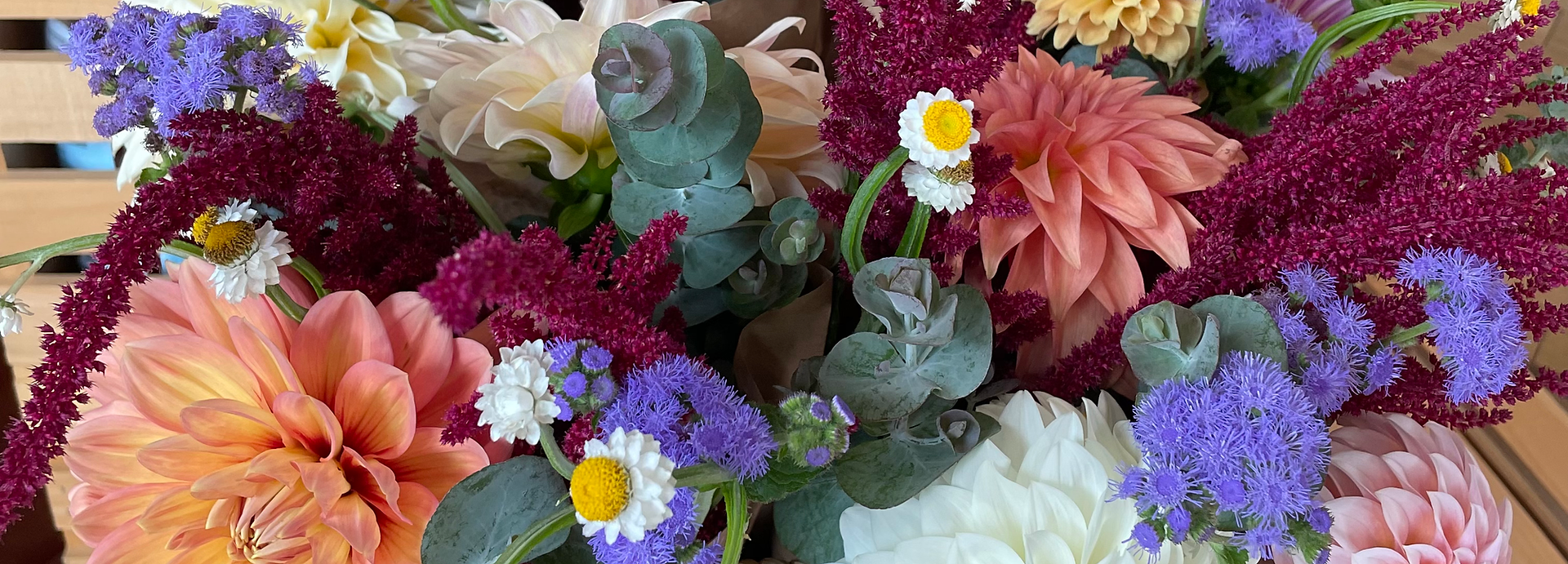 Colorful bouquet of mixed flowers in orange, purple, white, pink, and teal tones