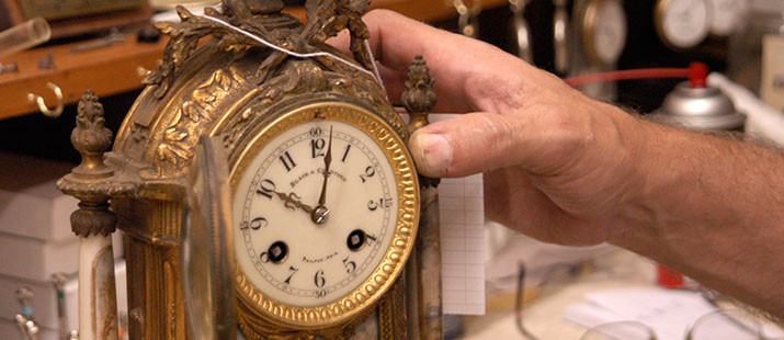 Hand holding an antique clock