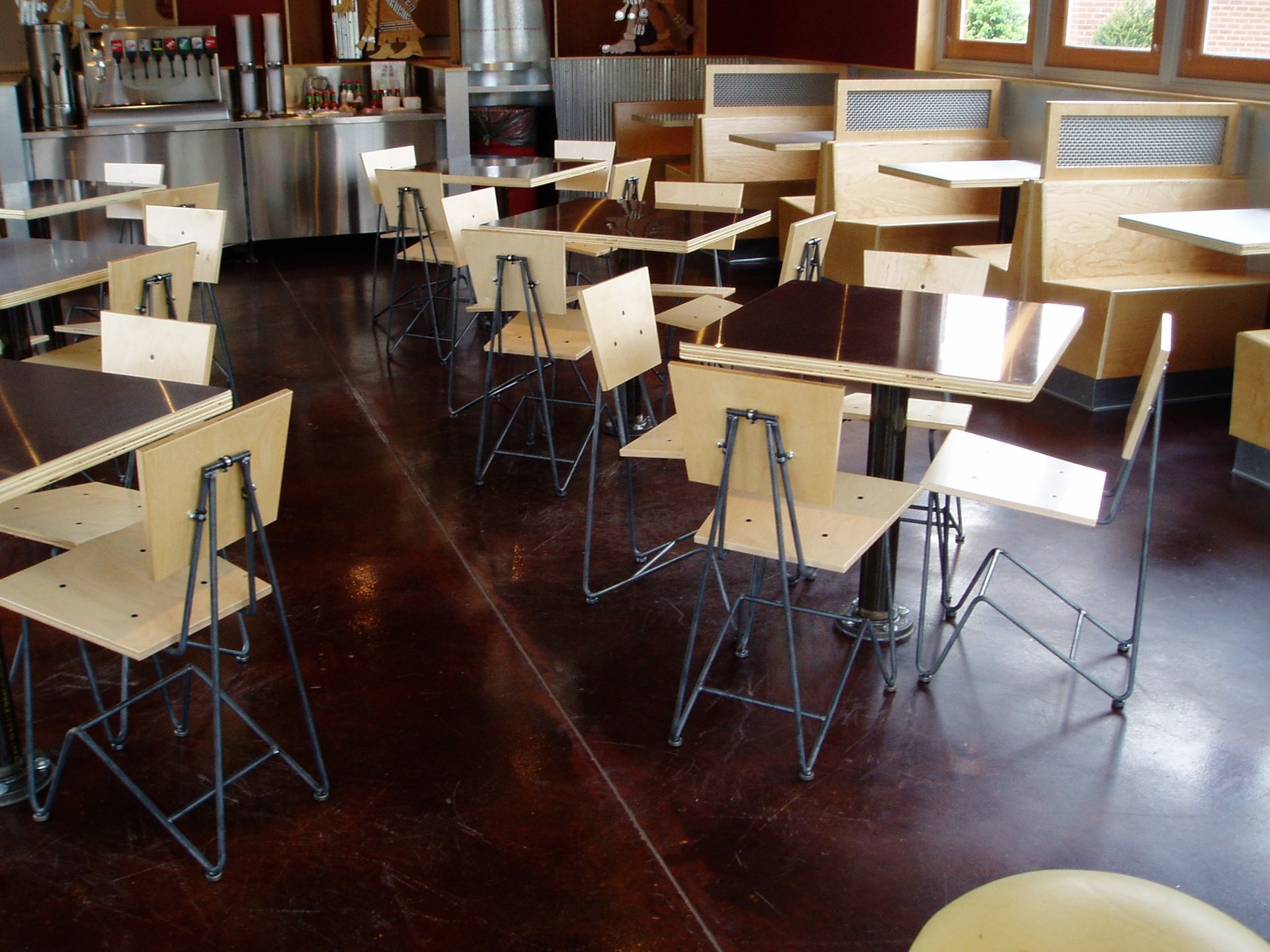 Empty cafe interior with brown tables and chairs on a dark wood floor.